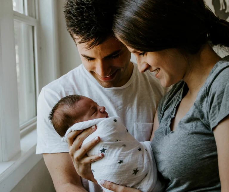 En nybakt mor og far holder sitt nyfødte barn
